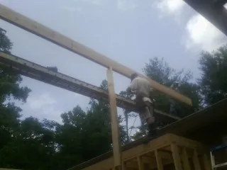 Carpenter setting a ridge beam over a new addition frame — Ice Dam Removal by Roofing Brothers in Offutt Afb