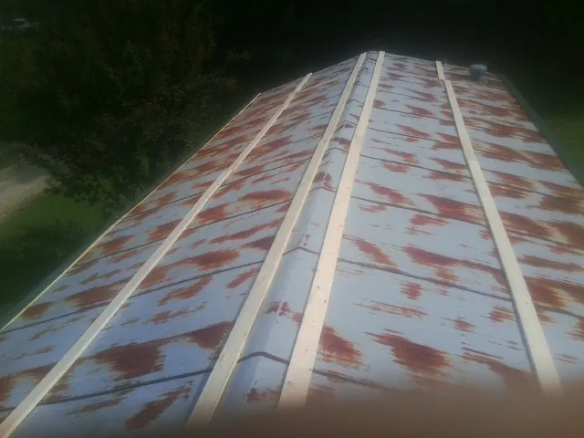 Rusted metal roof panels with new wood purlins before replacement — Storm Damage Roof Repair in Offutt Afb by Roofing Brothers