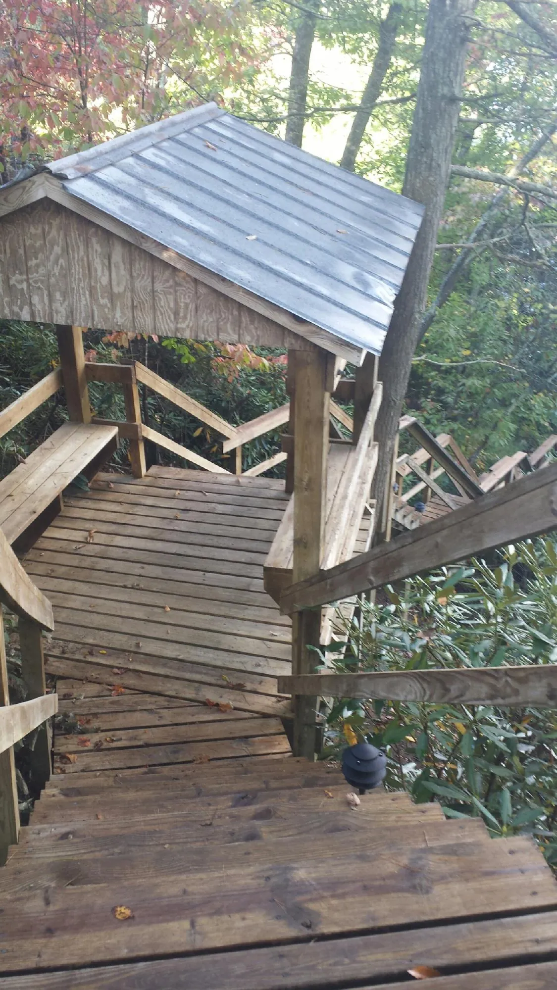 Metal roofed shelter over wooden steps on a wooded walkway — Skylight Repair & Installation work by our crew in Offutt Afb