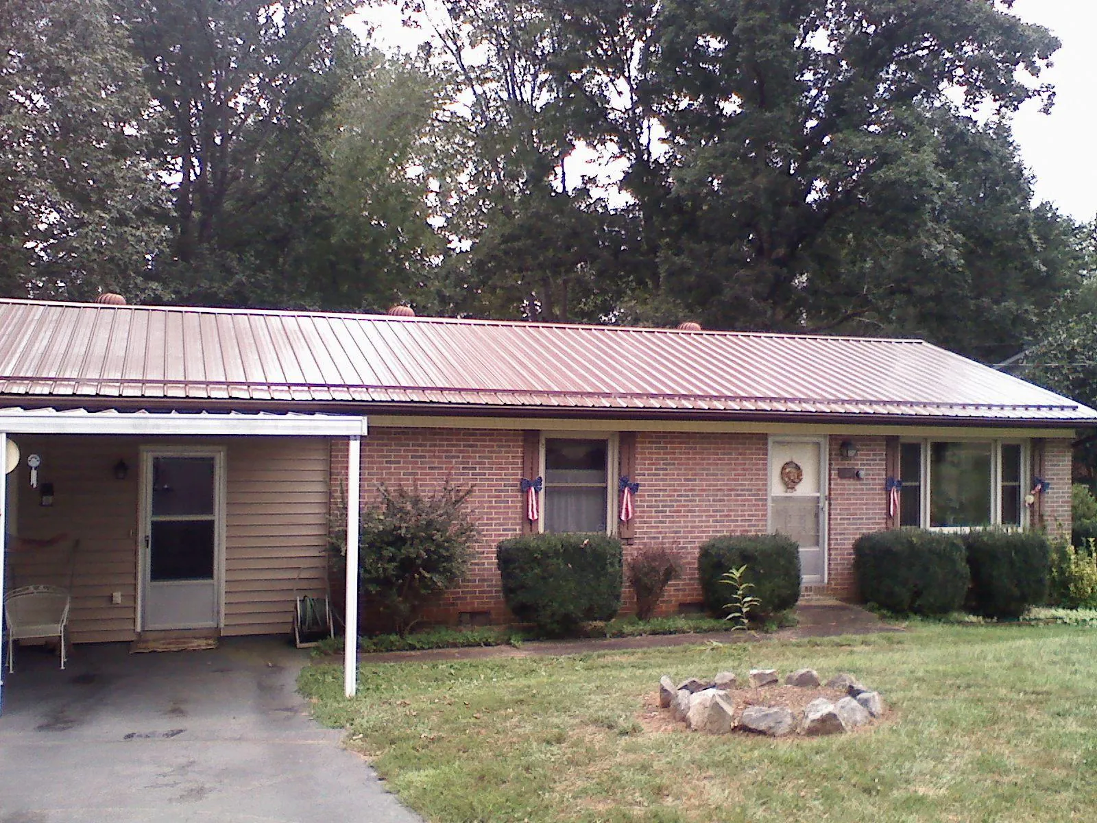 Bronze metal roof and carport on a brick ranch home — Roof Repair work by our crew in Offutt Afb